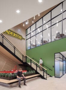 Two-story stairwell with light green and wood paneling accents. A farm implement displayed besides and the sign "Vaderstad" above.