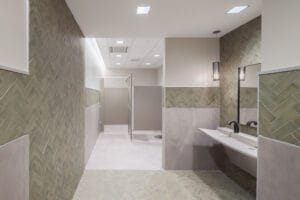 Building bathroom with light green and gray tiles.