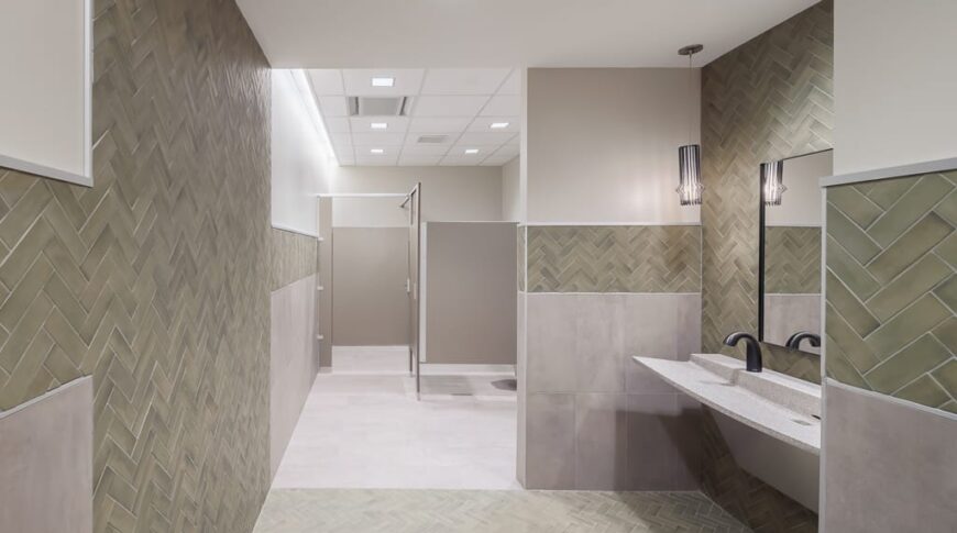 Building bathroom with light green and gray tiles.