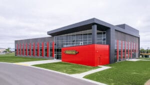 Exterior drone photo from the right of the Vaderstad precast building in red and gray accent colors.