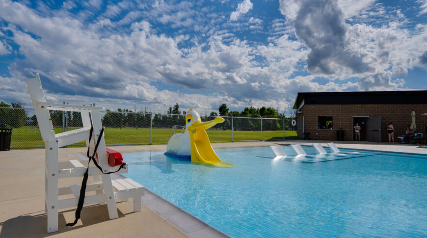 Gwinner Aquatic Center-Low Res-41 Zero-entry pool with pelican-shaped toddler slide and four sunken concrete lounge chairs.