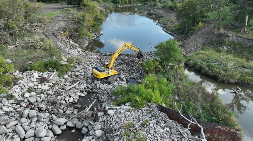 default Aerial view of Mayville Dam with bright yellow excavator clearing debris.