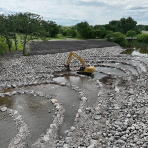 Excavator placing rocks in Goose River for rock riffle design from deconstructed dam.