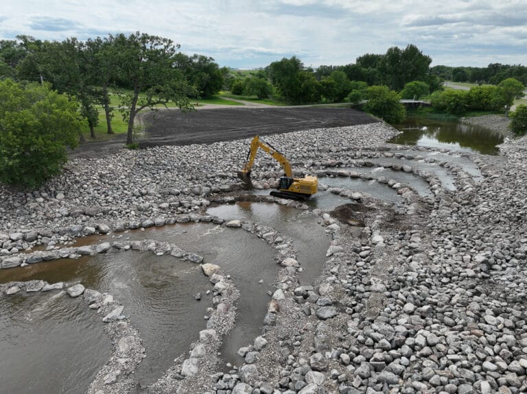 Excavator placing rocks in Goose River for rock riffle design from deconstructed dam.