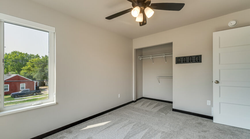 Bison Run Rentals - Low Res-29 Interior bedroom view with greige walls, window, ceiling fan, and closet.