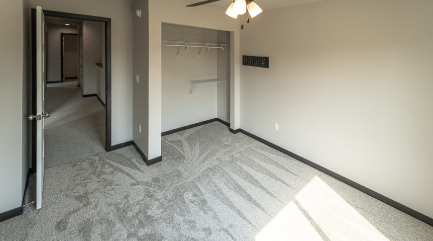 Bison Run Rentals - Low Res-8 Interior bedroom view with greige walls, ceiling fan, and closet.