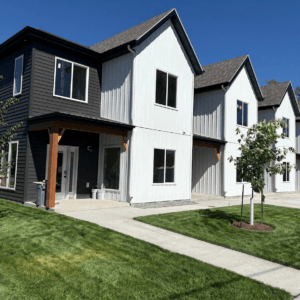 Exterior of Bison Lodge townhomes 6-plex with blue skies and green grass.
