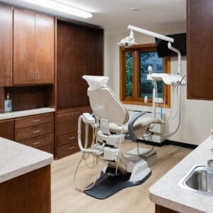 Dental station with brown wood cabinetry surrounding a dental chair.